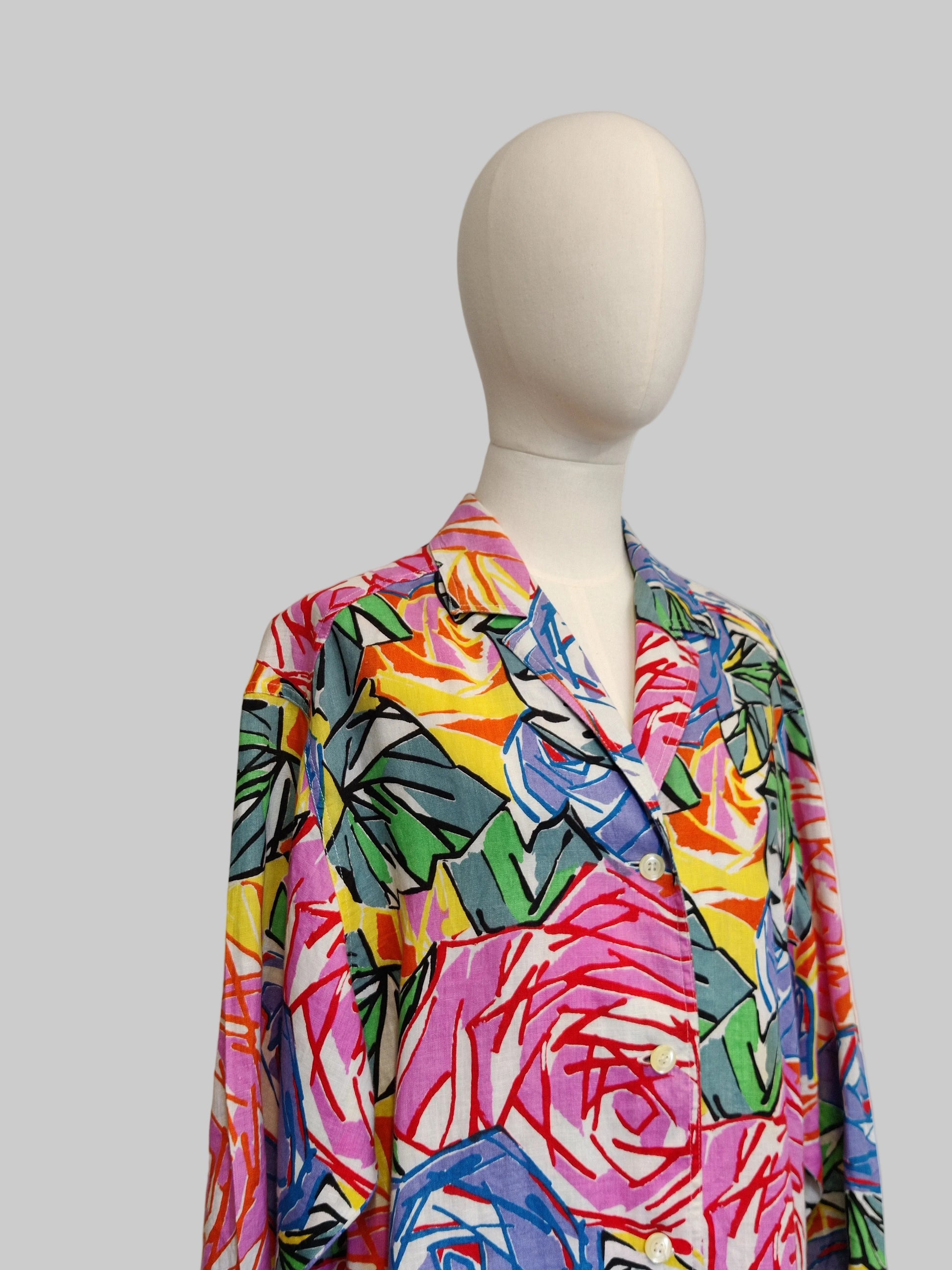 Mannequin wearing a colorful floral patterned shirt against a plain background